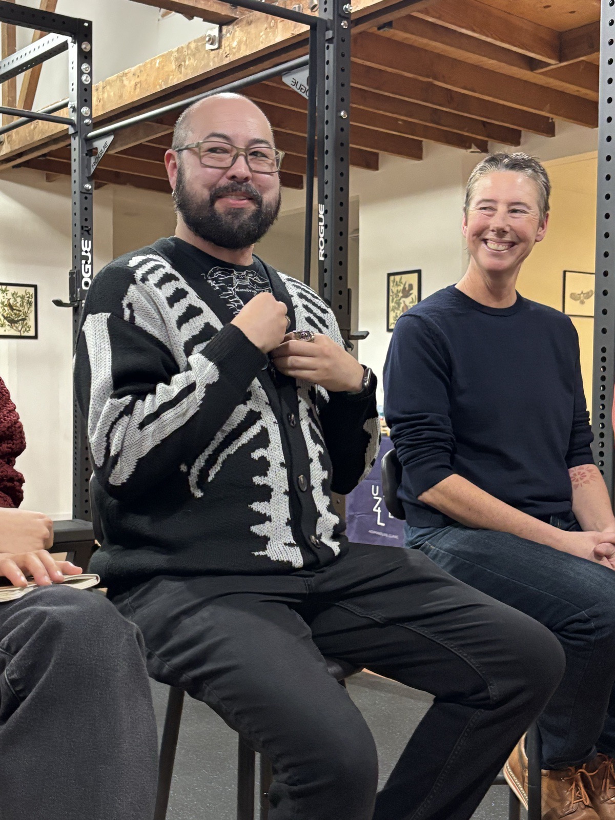 Two healers seated mid-laugh during the panel