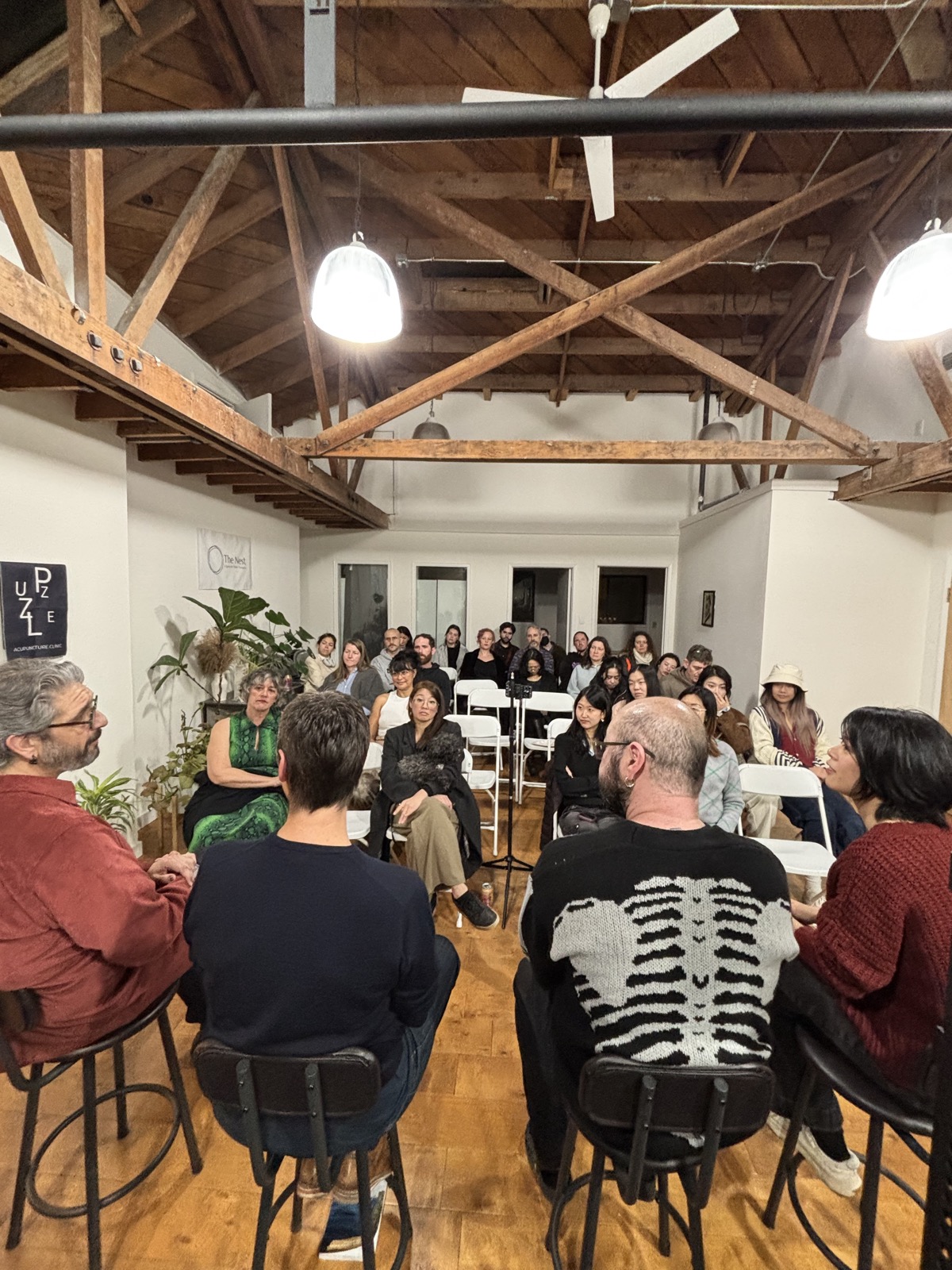 Wide view of the room from behind the panelists, full house