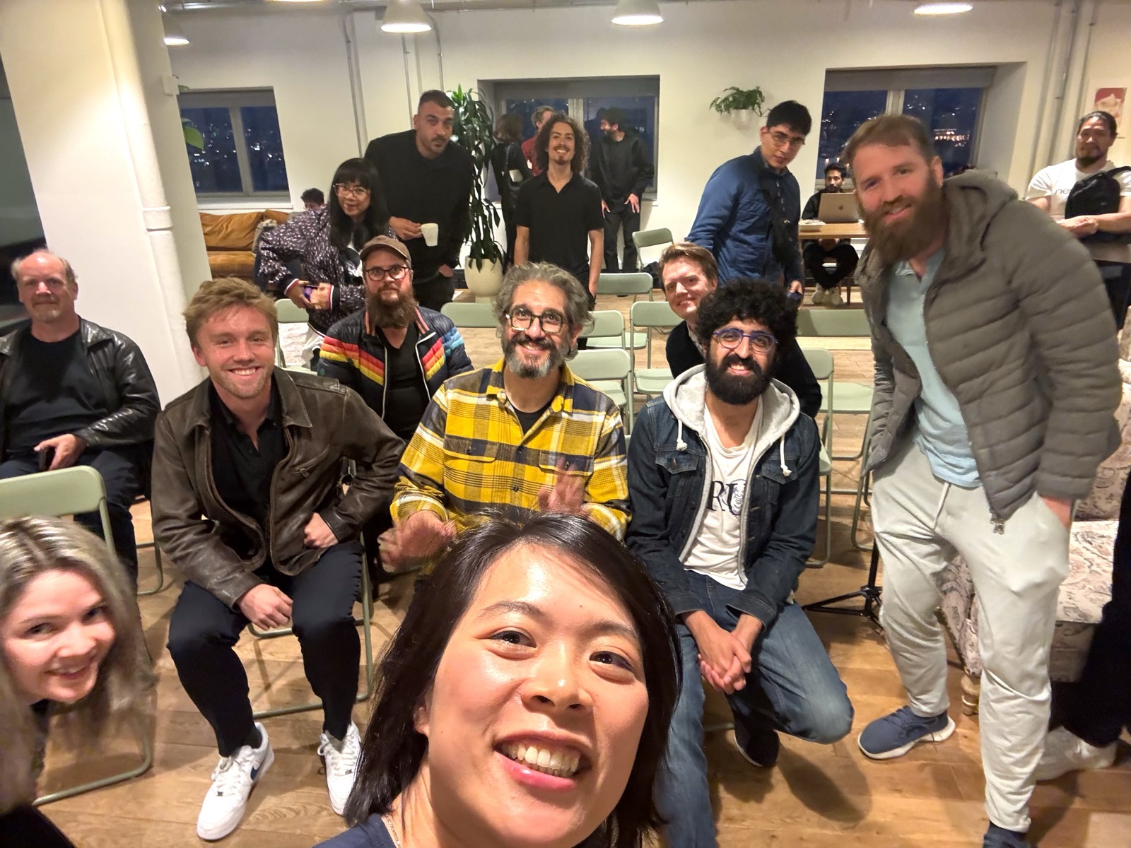 Jenny grinning into the camera, panelists and audience behind her
